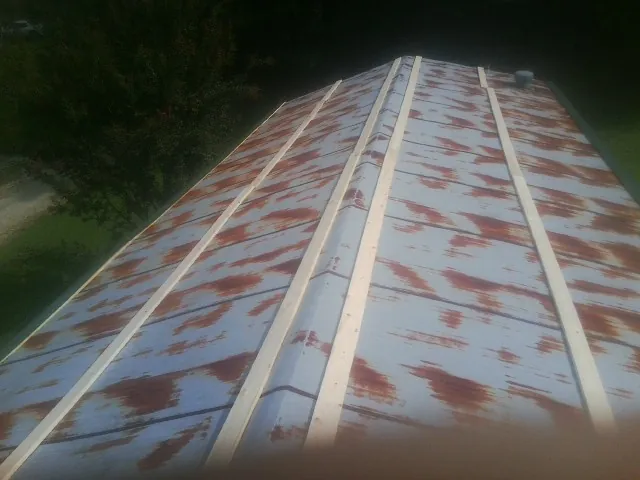 Rusted metal roof panels with new wood purlins before replacement — Storm Damage Roof Repair in Morven by Roofing Brothers